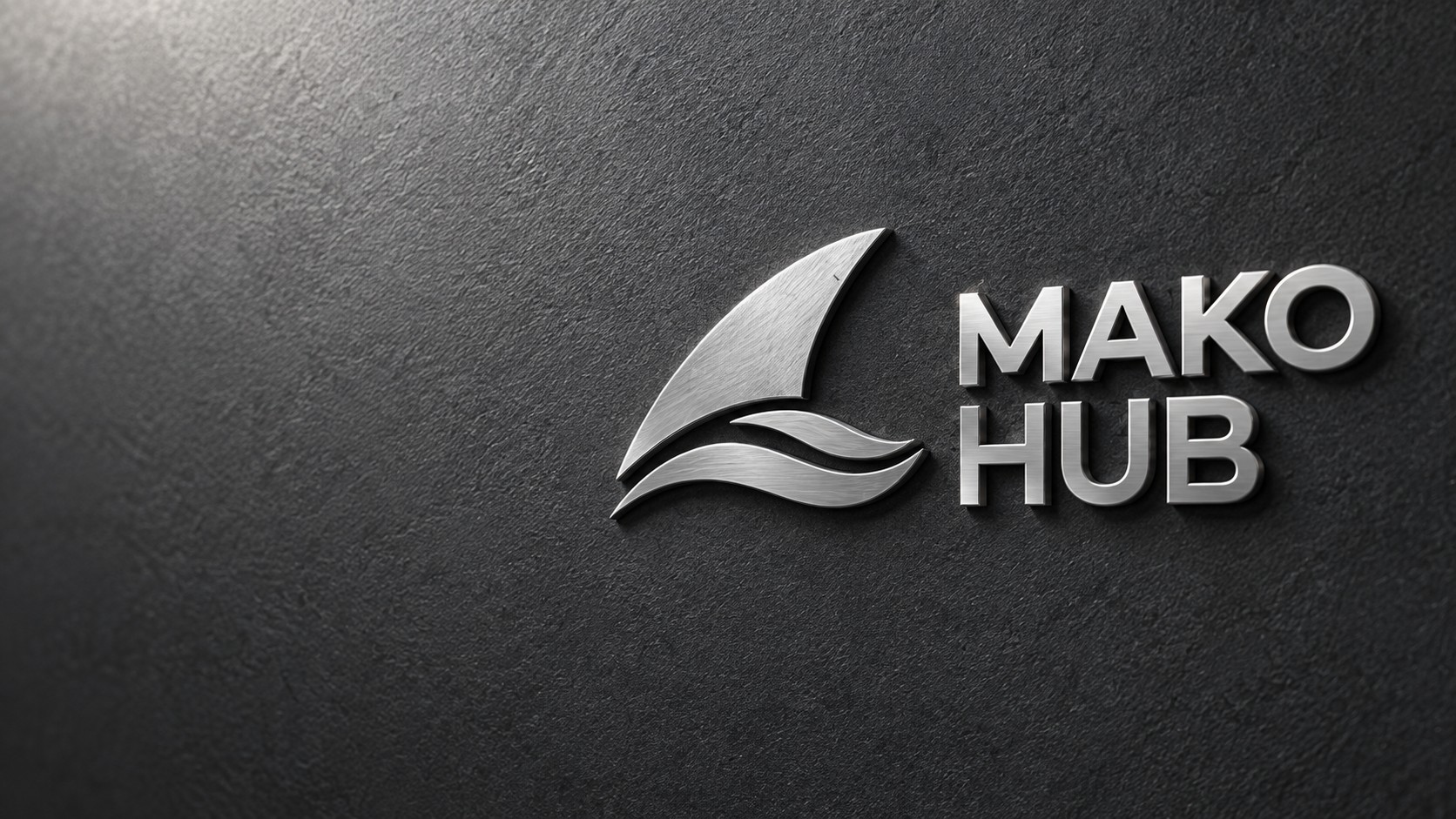 Silbernes MAKO HUB Logo als erhabenes Metall auf grauer Oberfläche